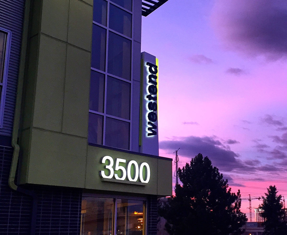 Westend Apartments illuminated blade sign and sunset