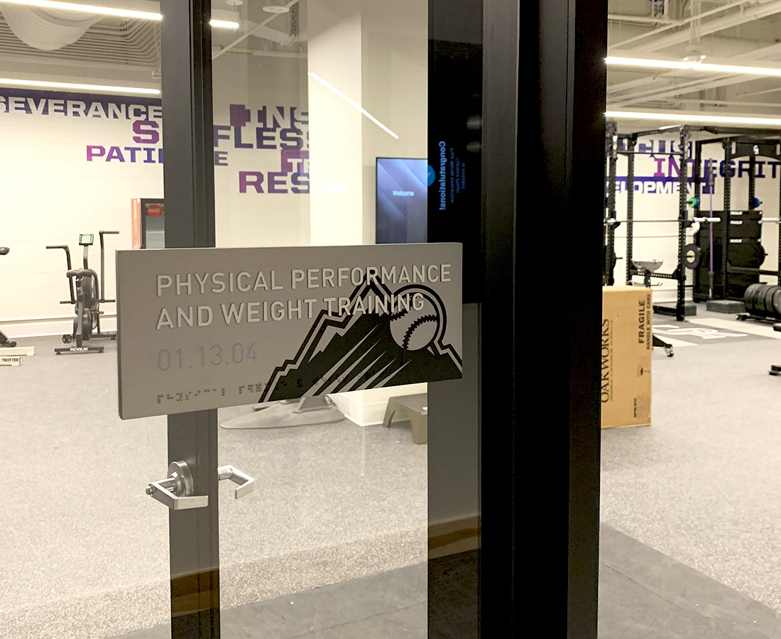 Gray ADA sign for fitness center at the Colorado Rockies Clubhouse at Coors Field