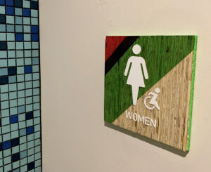 Colab Apartments interior restroom sign pink, blue and green kirei board
