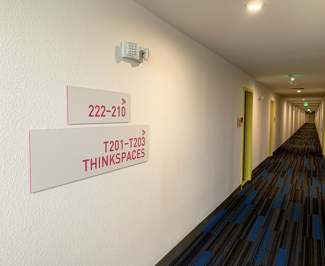 Colab Apartments interior wayfinding hallway signage pink