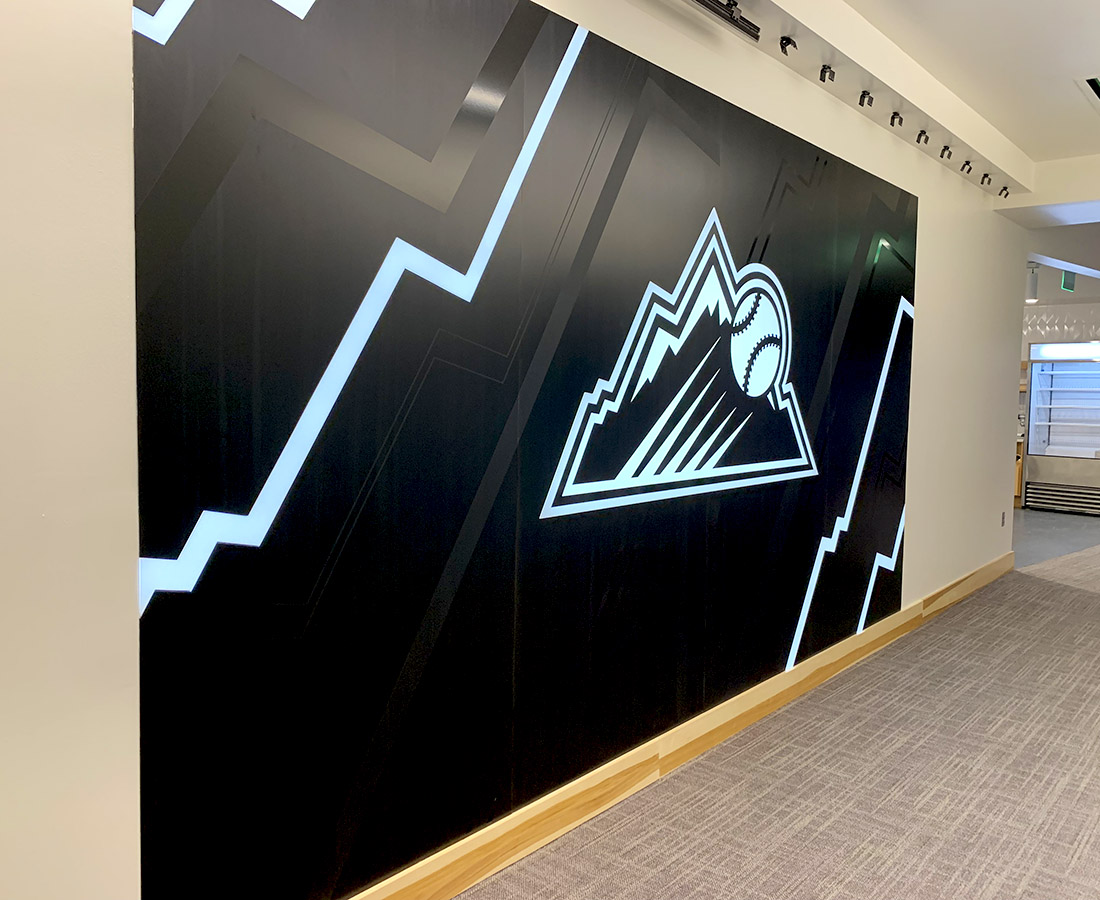 Illuminated steel Rockies logo graphic wall at the Colorado Rockies Clubhouse at Coors Field
