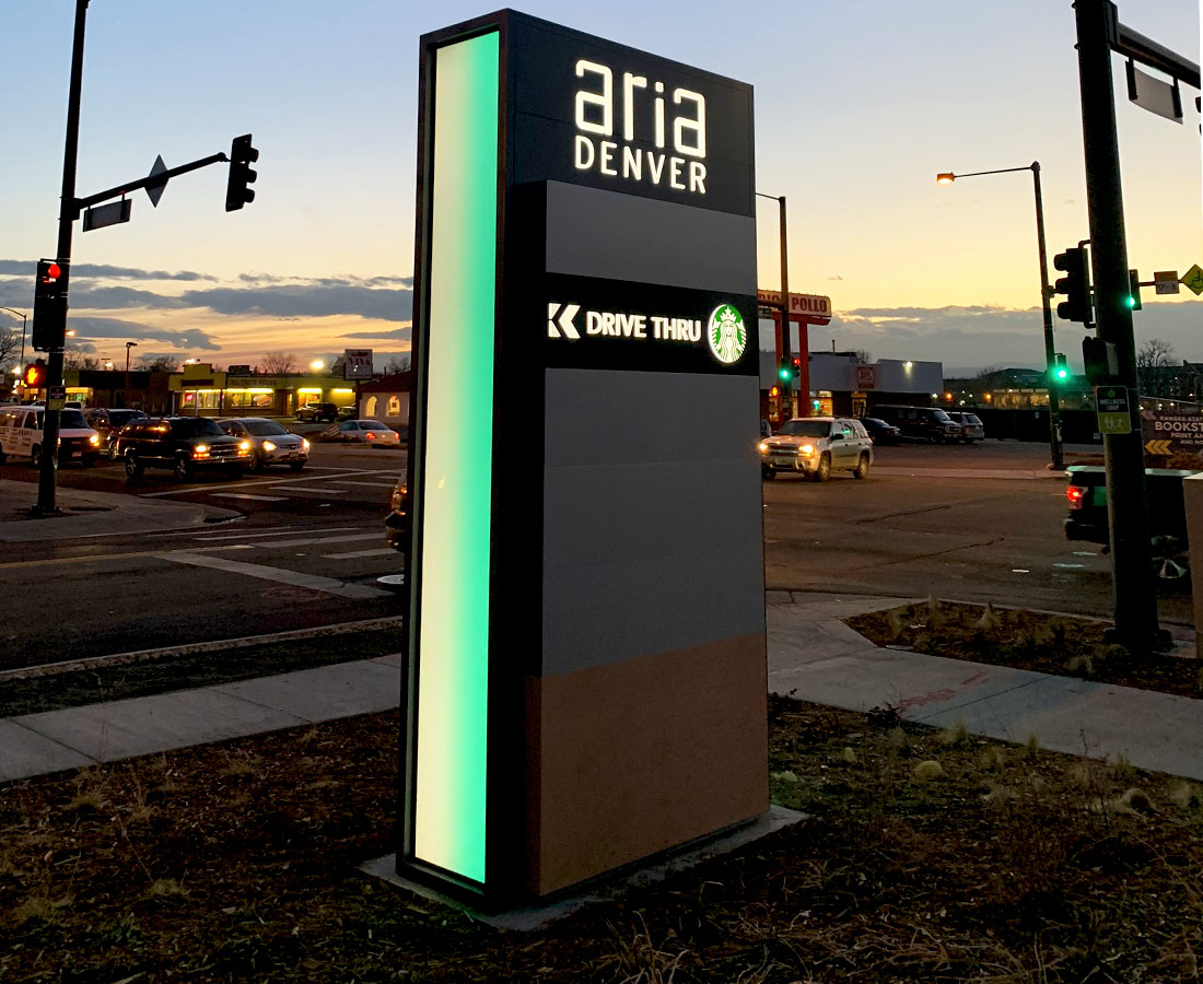 Aria Denver illuminated color changing monument sign, Starbucks tenant panel