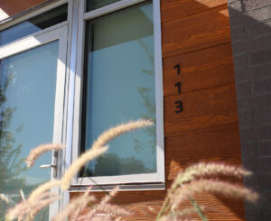 Unit entry sign on rustic wood paneling, a welcoming feature at Hyve in Salt Lake City.